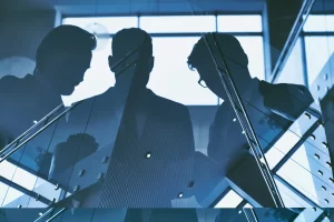 Business men meeting in the dark behind an office window